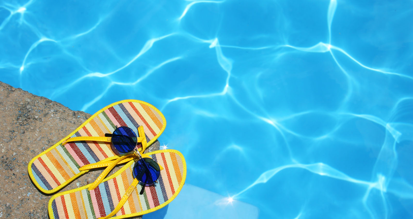 Yellow stripe slippers beside the pool